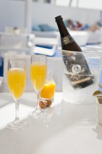 Mimosa in a champagne glass with champagne in an ice bucket